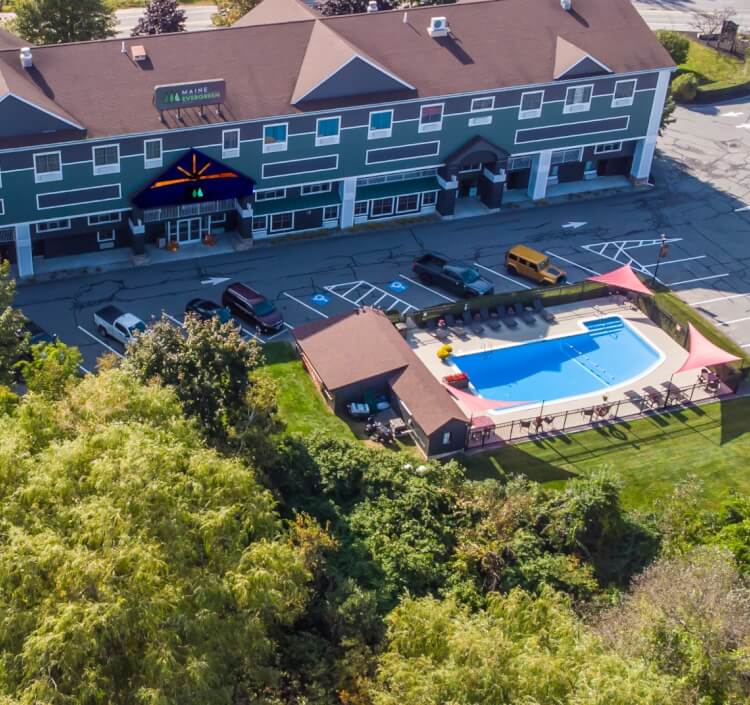 a building with cars parked in front of a pool