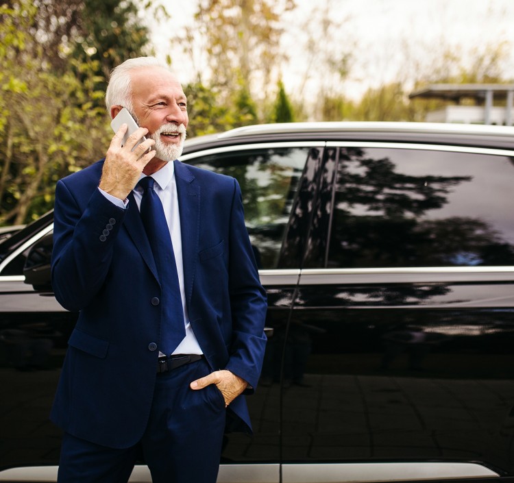 man standing outside of the car on the phone