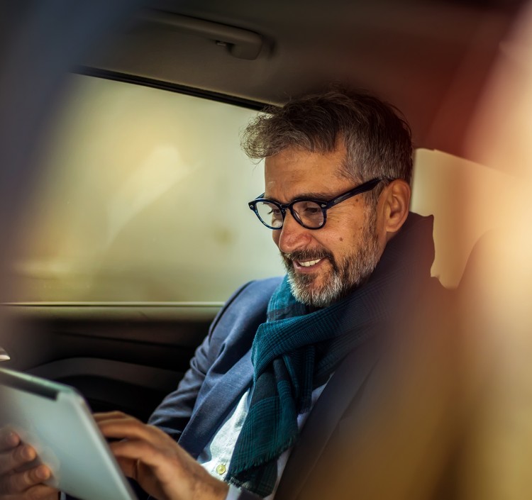 man in car looking at tablet