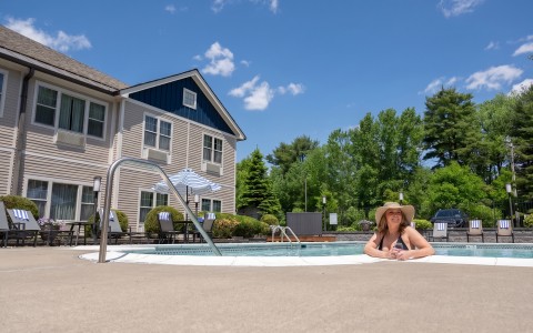 a woman in a garment and hat by a pool