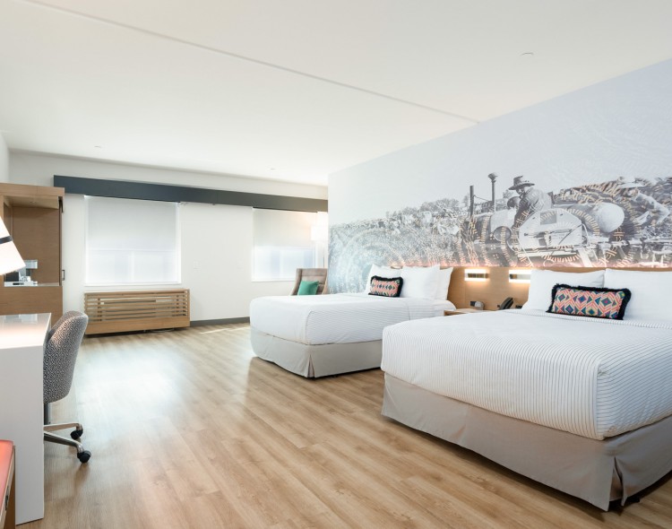 a room with two beds and a chair