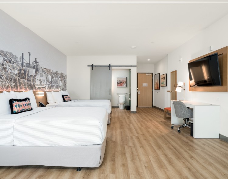 a room with two beds and a desk