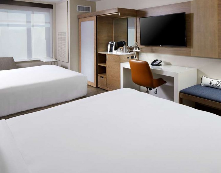 two queen beds in room with desk and tv