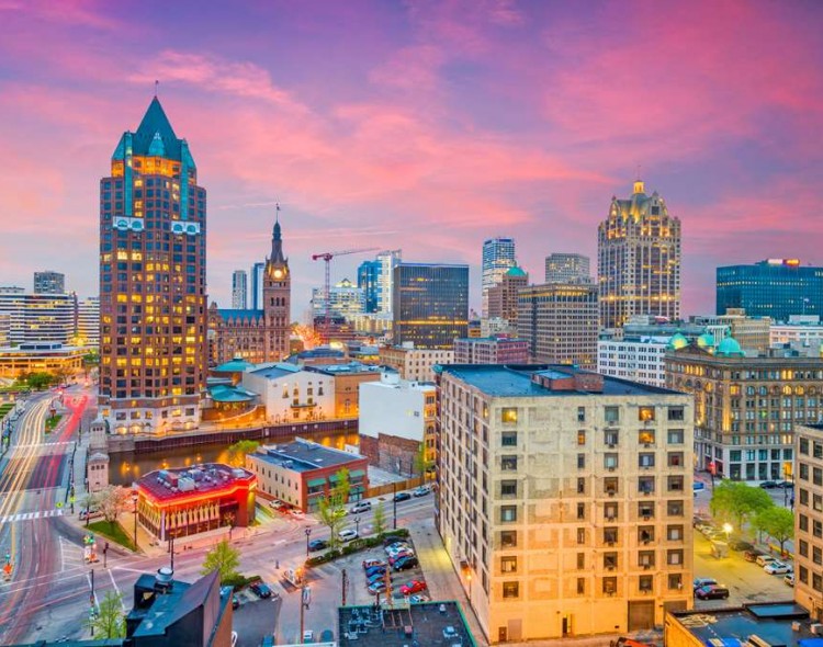 view of skyscrapers in city during sunset with pink sky