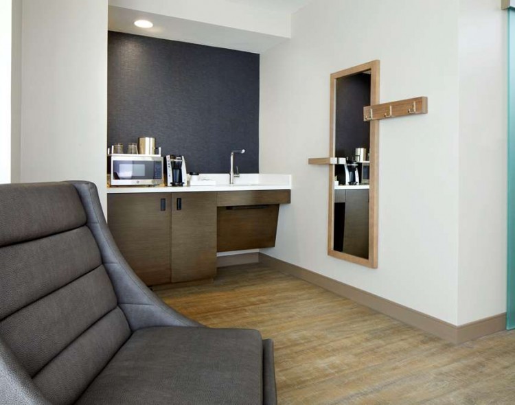 chair in guest room near coffee maker and microwave