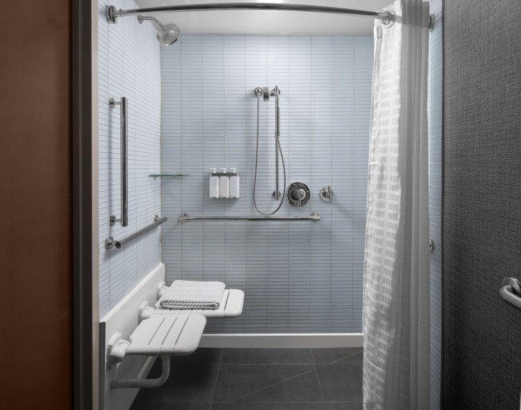 a shower with a bench and a shower head