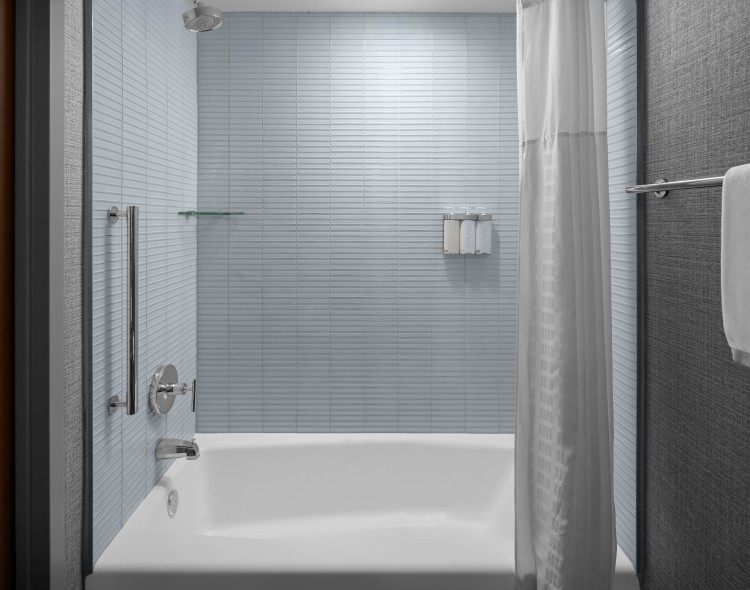 a white shower curtain and tub