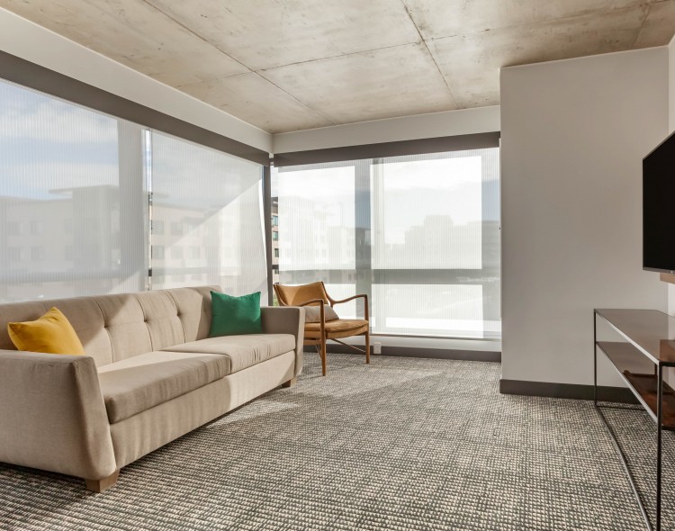 a living room area inside of a guest suite with natural light