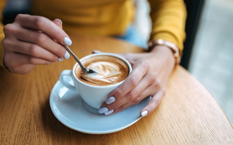 a person holding a cup of coffee