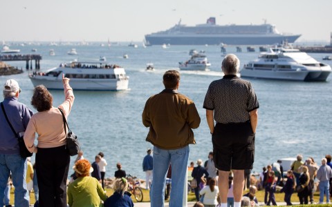 a group of people looking at a large ship in the water