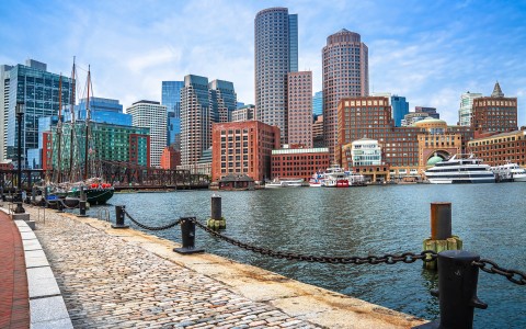 a city skyline with boats and a body of water
