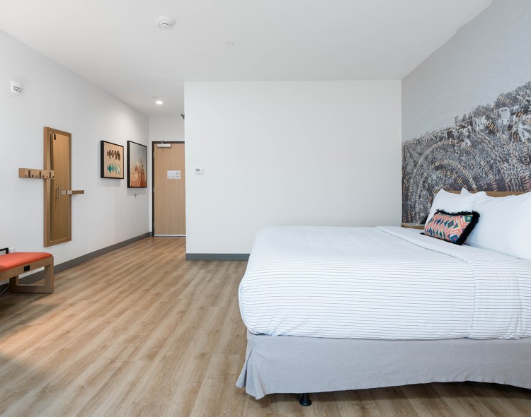 a room with a bed and art on the wall