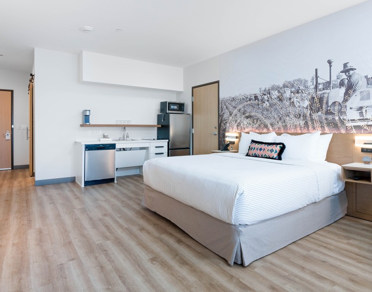 a room with a bed and a refrigerator