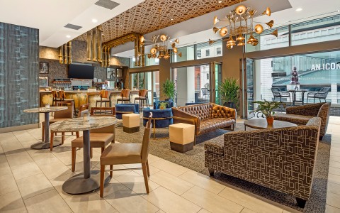 a room with a large chandelier and tables and chairs