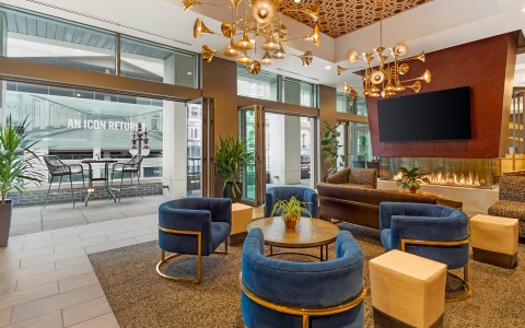 a room with blue chairs and a chandelier