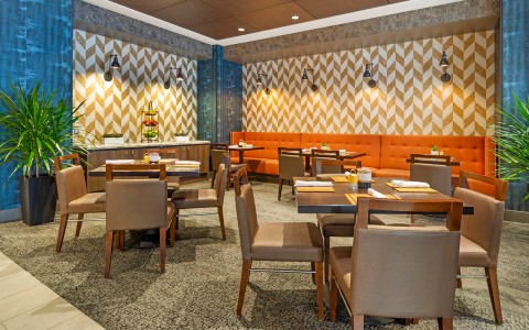 a restaurant with orange booth and tables