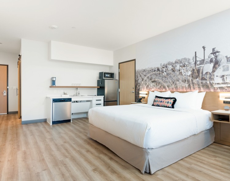 a room with a bed and a refrigerator