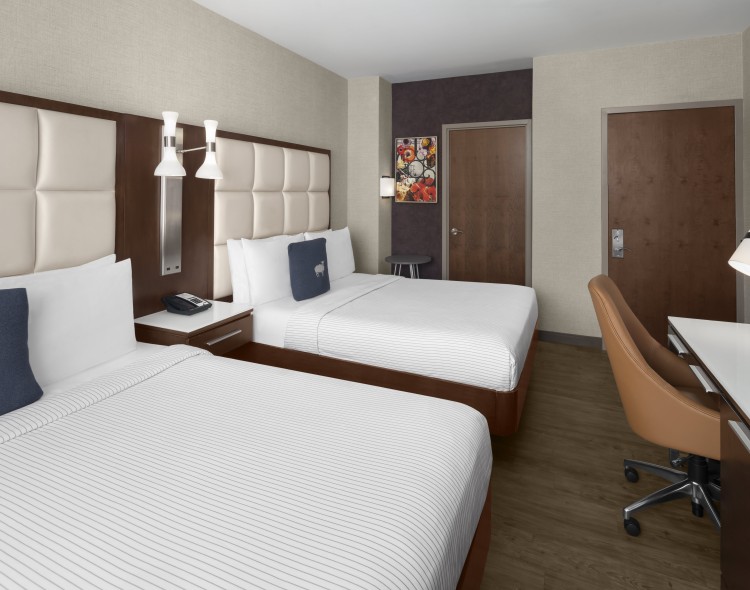 a room with two beds and a chair