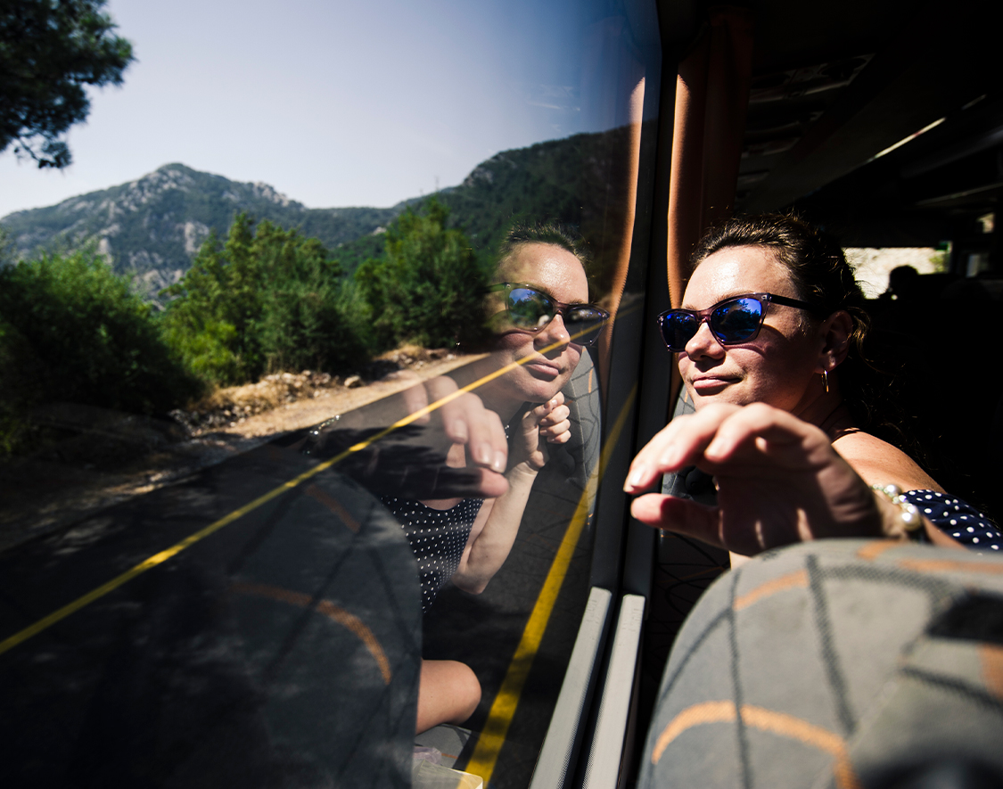 a woman looking out a window of a bus