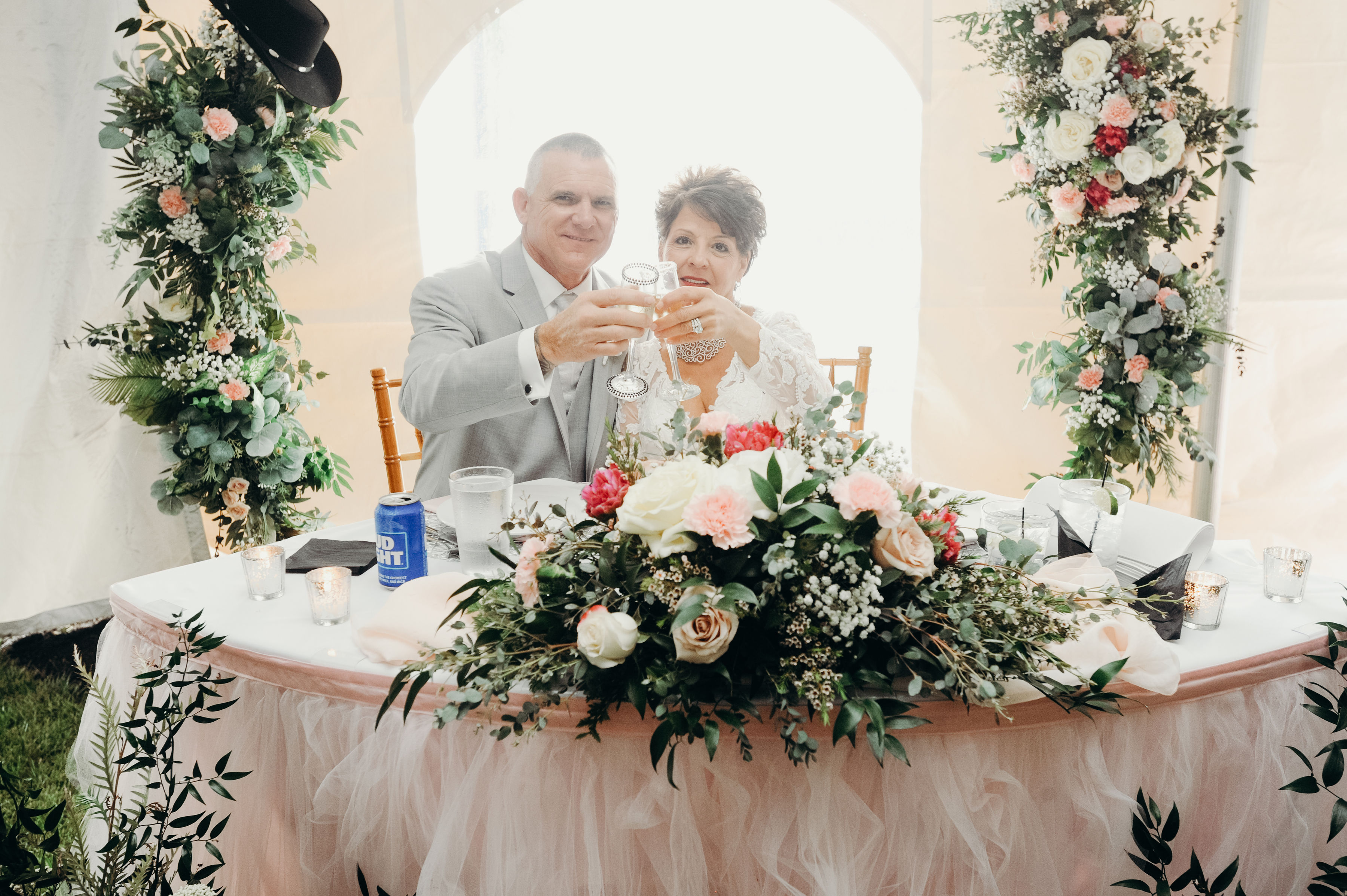 a man and woman sitting at a table with flowers