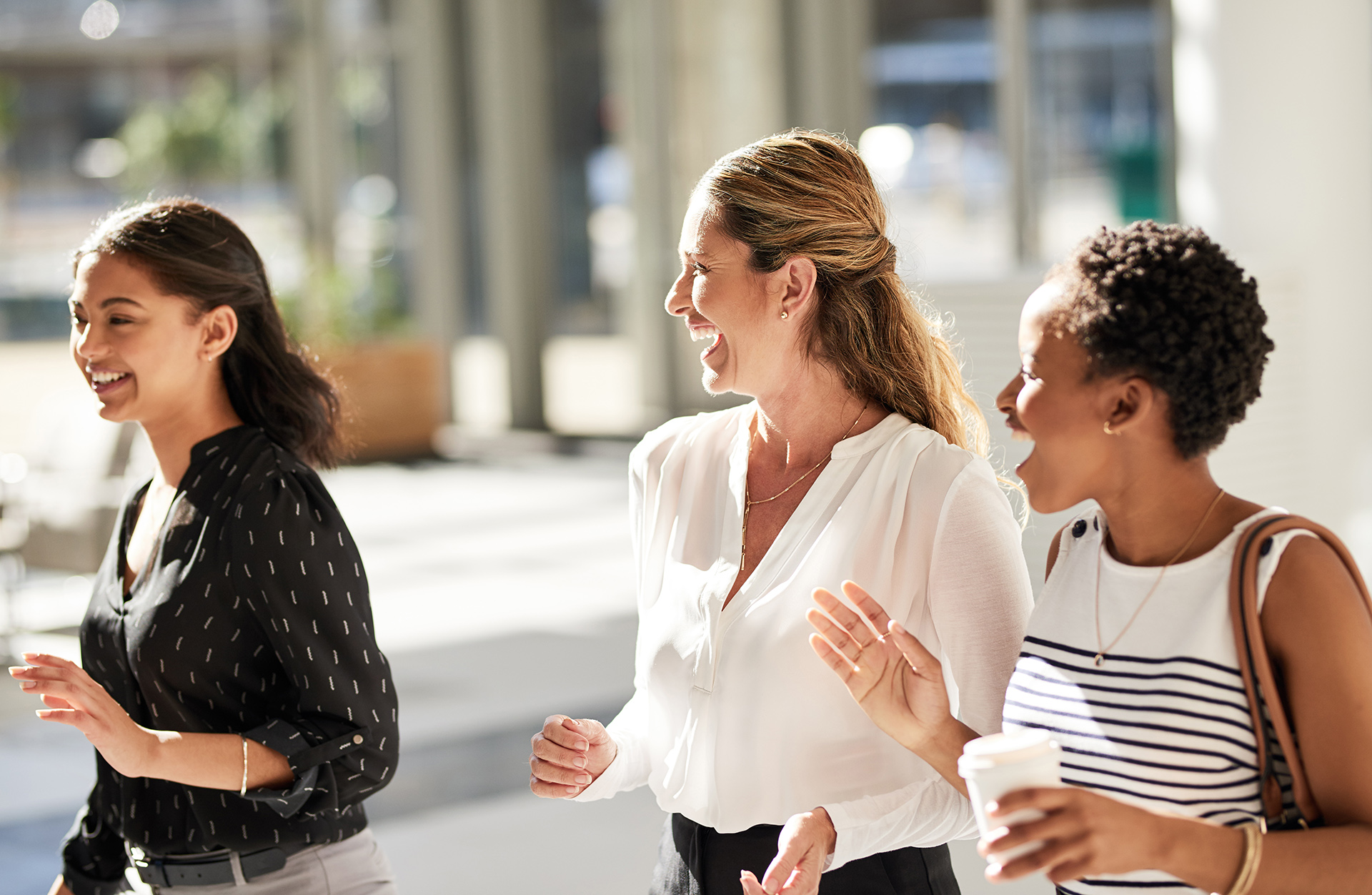 three women walking and talking in street