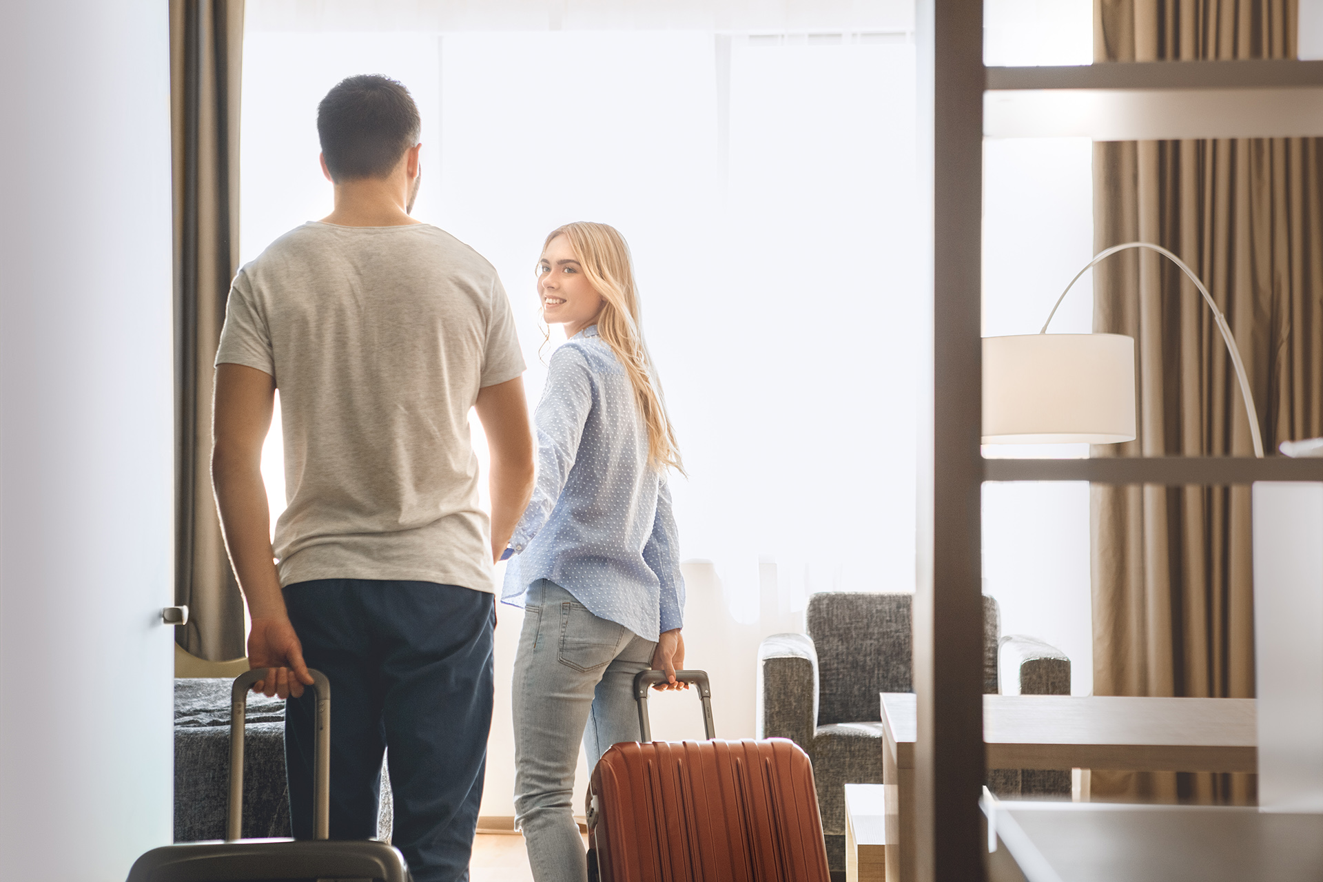 couple rolling their luggage into their room
