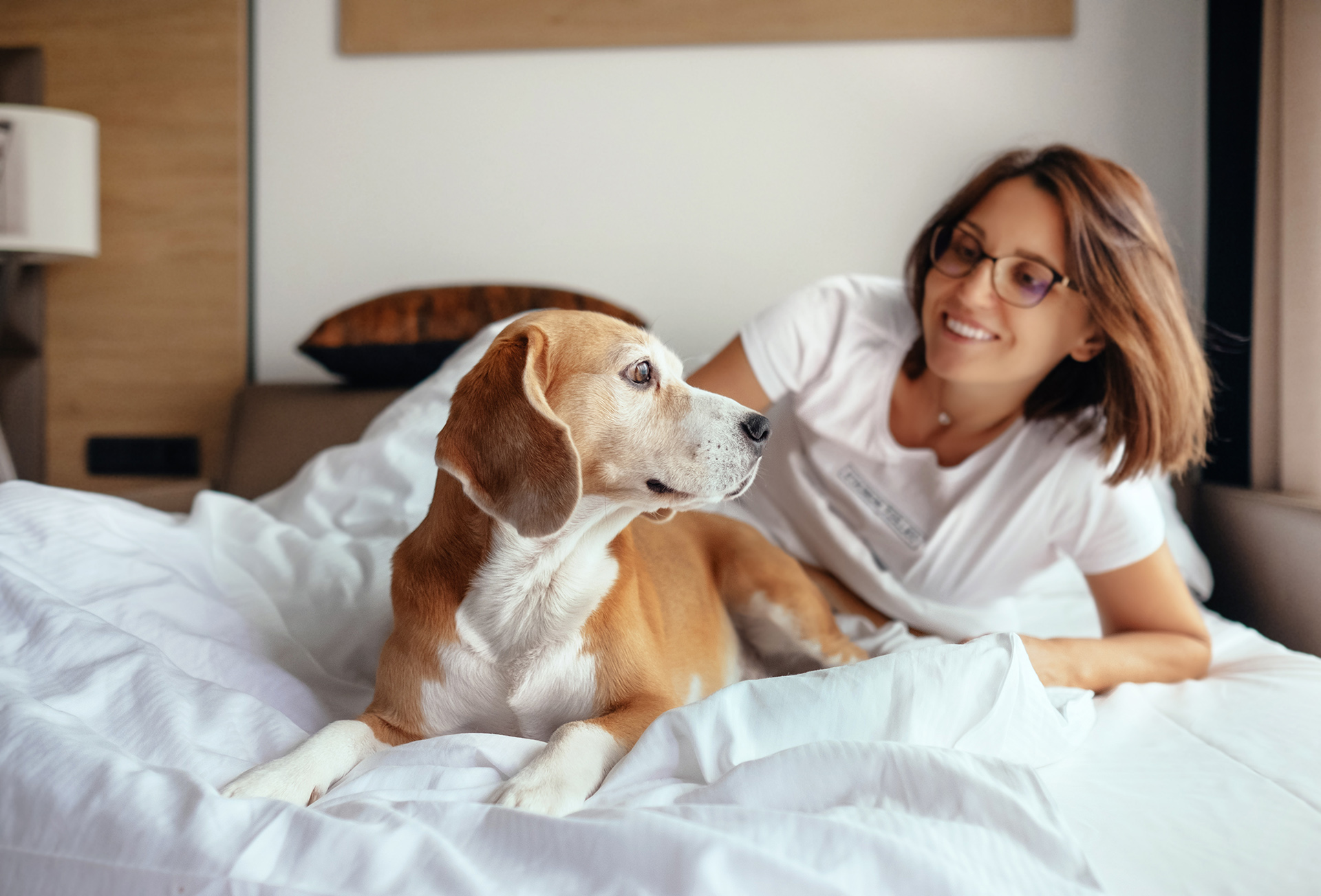 A dog and a woman laying in bed