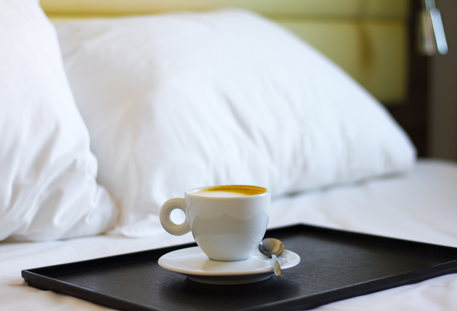 mug of coffee on a tray in bed