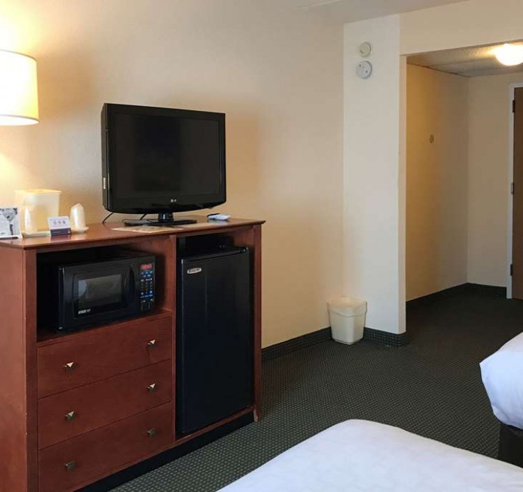 two beds, tv, microwave, and mini fridge in guest room