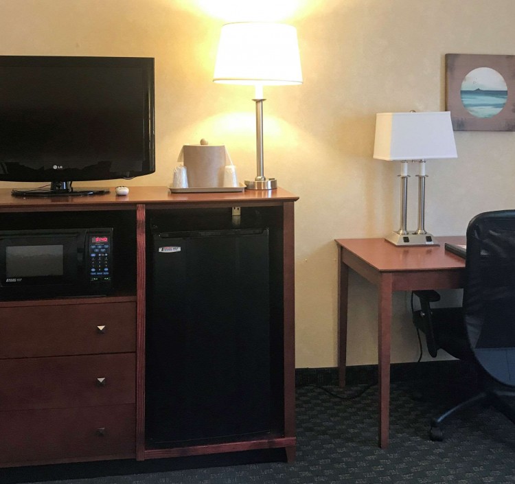 desk area, tv, microwave, and mini fridge in guest room
