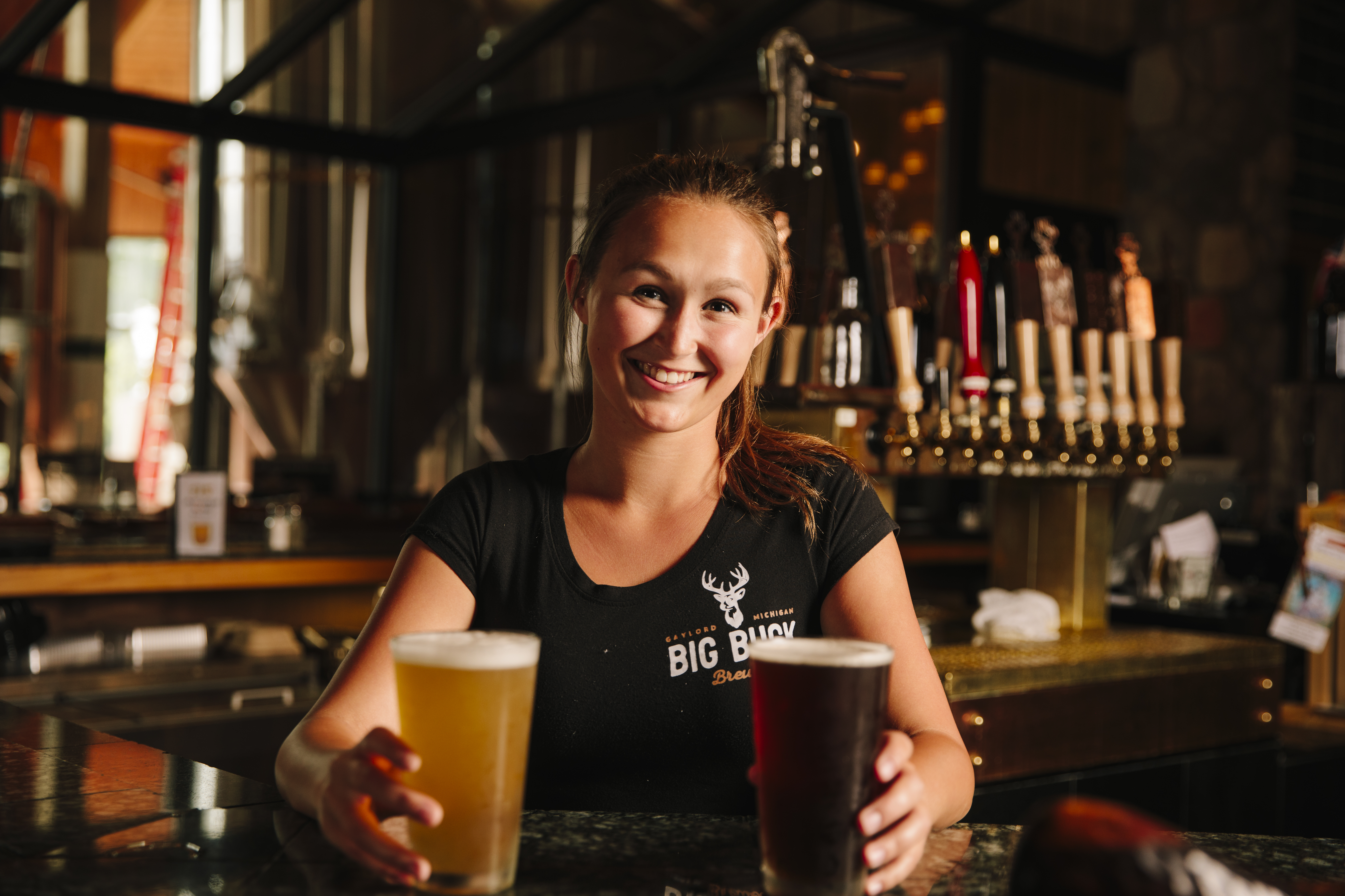bartender smiling serving 2 beers