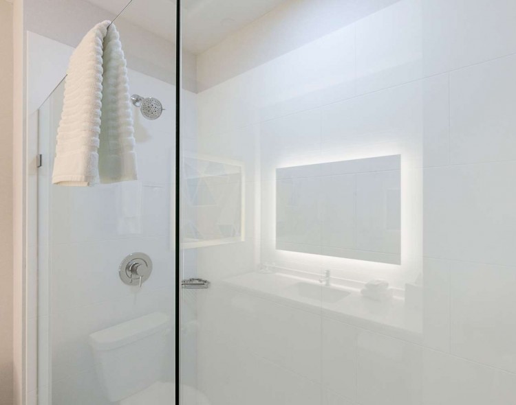 white tiled shower with towel hanging over glass