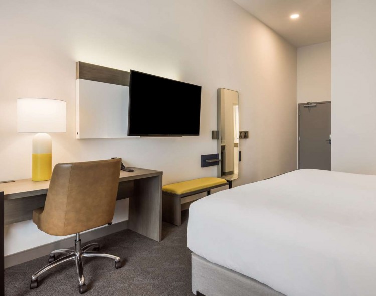 king bed with mounted tv and desk across from it