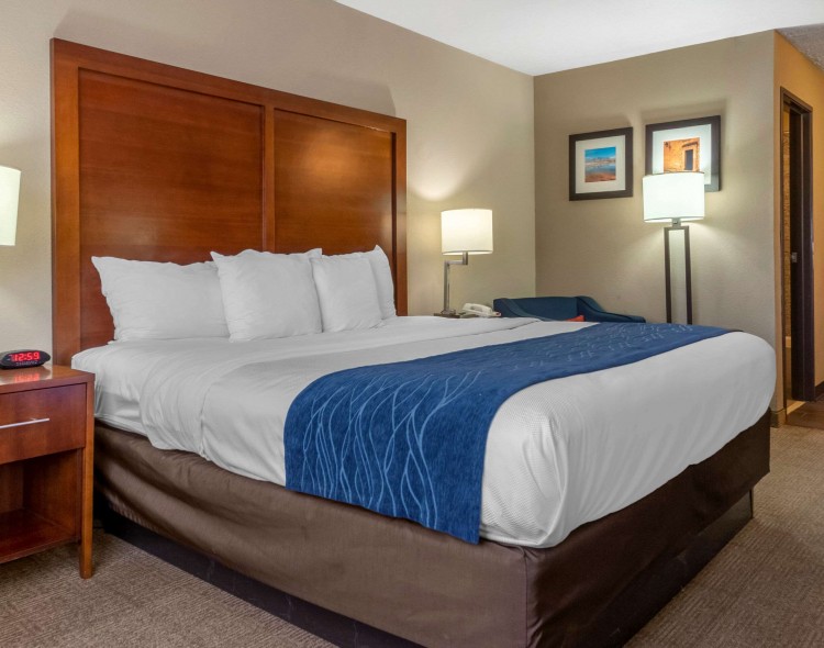 Guest room with king bed and wooden headboard