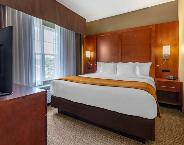 a guest suite with a king bed an orange decor