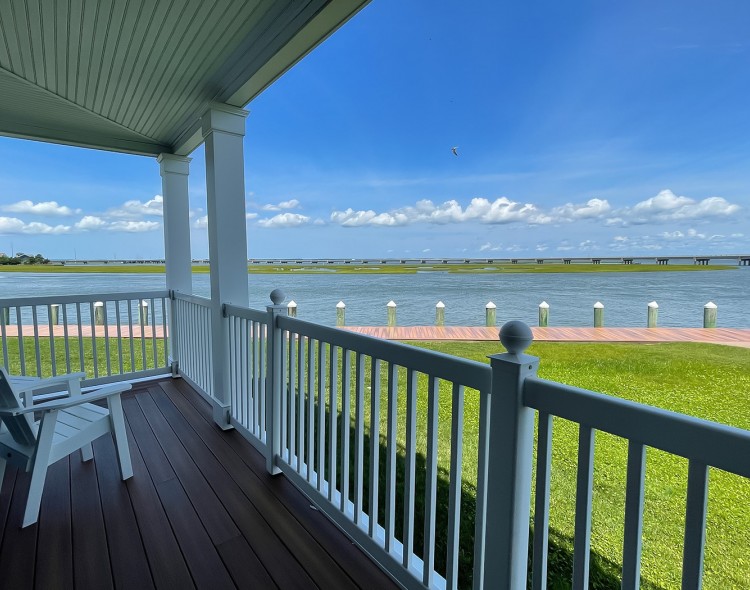 lake view from a large balcony and a white wooden chair