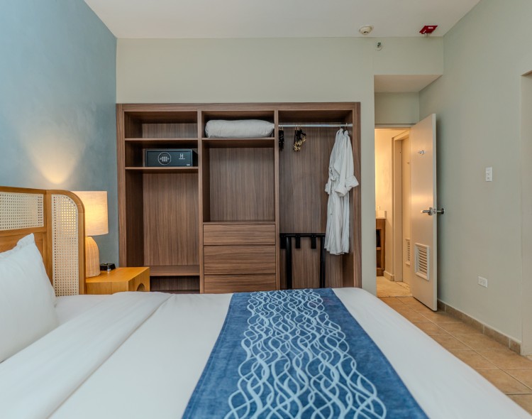 a bed with a blue and white blanket in a room with a closet