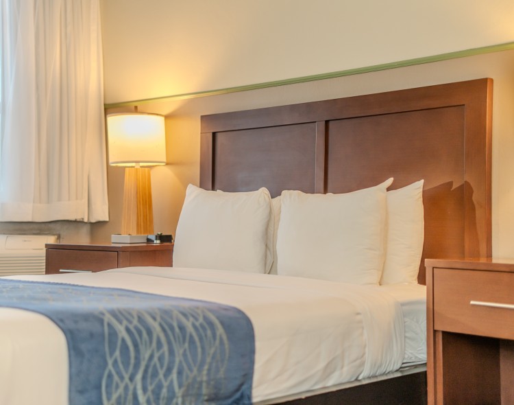 a bed with white pillows and a lamp