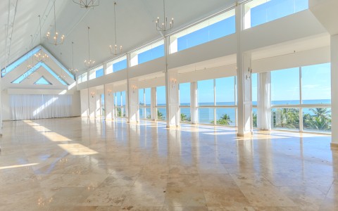 a large room with large windows and a view of the ocean