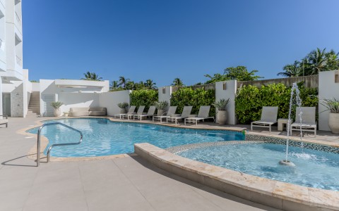 a pool with lounge chairs and a pool in the background
