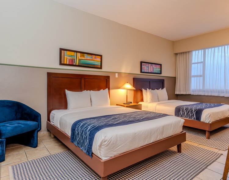 a room with two beds and a blue chair