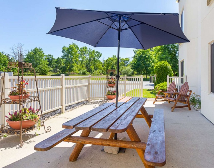 outdoor picnic bench with other chairs and plants