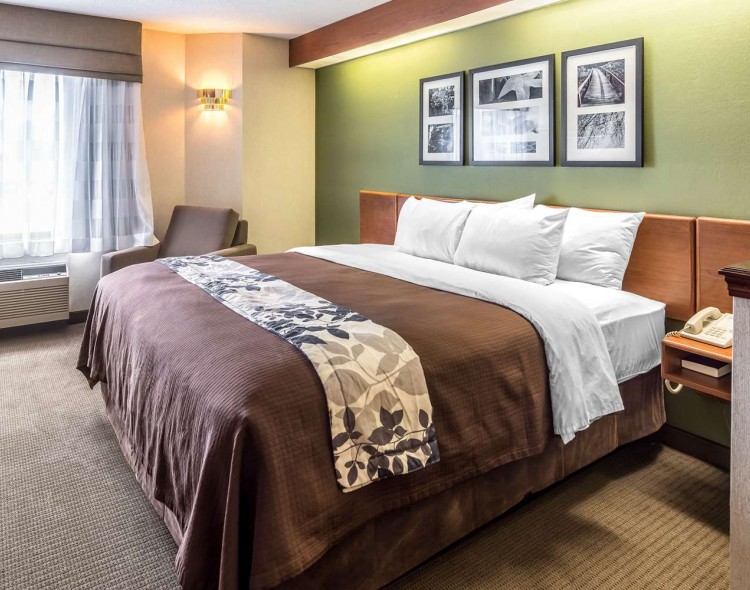 king bed with flowered bed runner and images above the bed