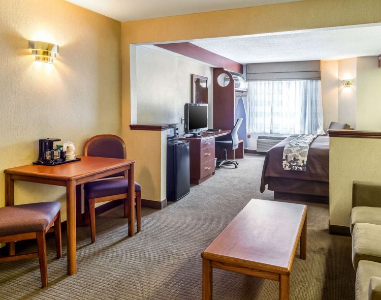 living room of suite with small dining table leading into bedroom