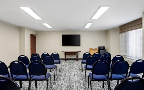 a room with blue chairs and a television