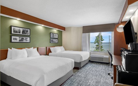 a room with two beds and a desk