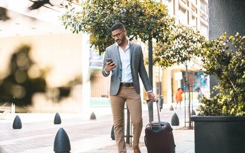 a man walking with a suitcase and phone