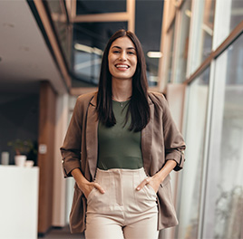 a woman smiling with her hands in her pockets