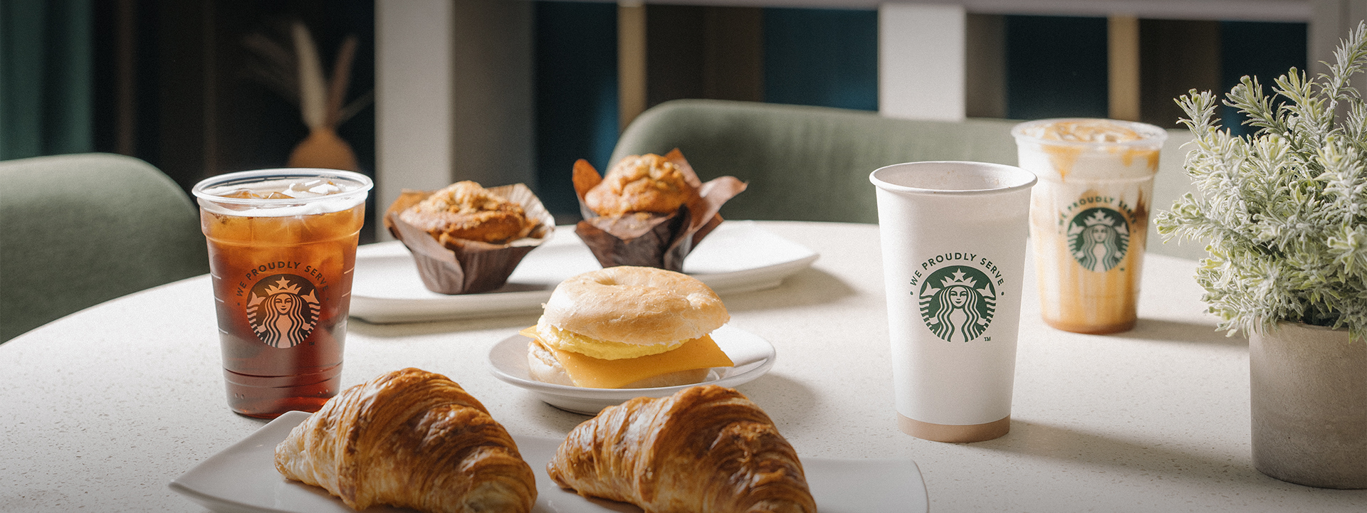 a breakfast table with croissants and a sandwich