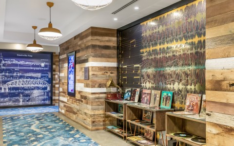 stylish interior hallway featuring rustic wood-planked walls and a blue patterned carpet runner.